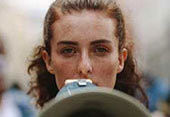 Mulher com um megafone a reclamar.
